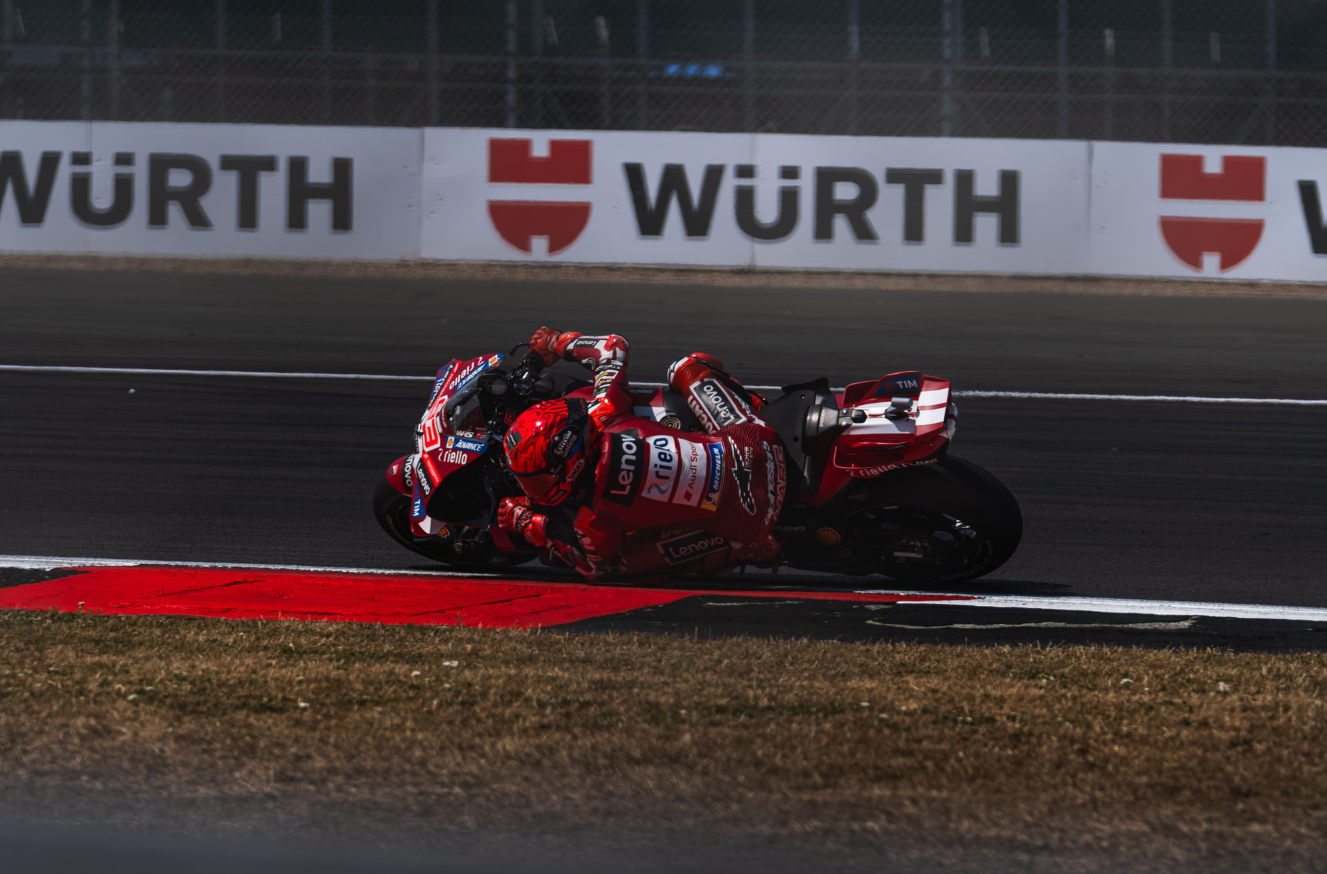 Motorsport photography: rider leaning hard into a fast corner at full commitment
